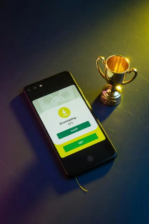 Teléfono Android junto a un trofeo dorado